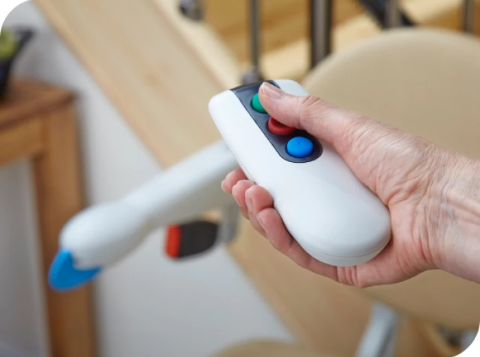 persoon gebruikt afstandsbediening van Simplicity traplift in achtergrond