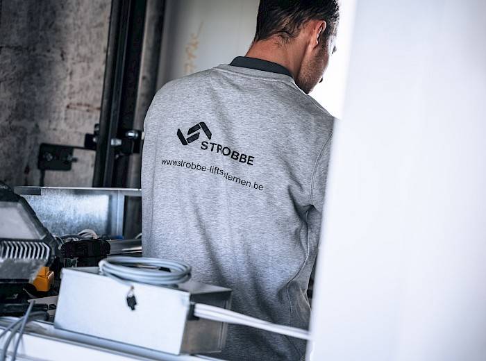 Man die werkt aan lift met logo van Strobbe